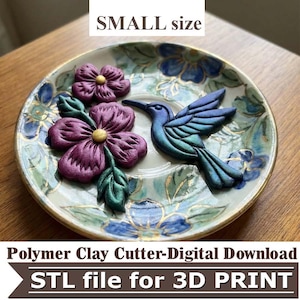 May include: A small decorative plate with a hummingbird and flower design. The hummingbird is blue and green, and the flowers are purple with gold centers. The plate has a floral pattern and the text "SMALL size".