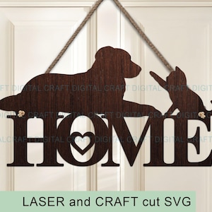 Könnte beinhalten: Holzschild "HOME" mit Hund- und Katzensilhouetten, an einem Seil aufgehängt. Das Wort "HOME" hat einen herzförmigen Ausschnitt im "O". Das Schild ist braun und hängt vor einer weißen Tür. Der Text unten lautet "LASER and CRAFT cut SVG".