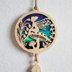 Puede incluir: Una taza de cerámica blanca con asa negra y el texto "But First, Coffee" en negrita negra. La taza se encuentra sobre un fondo borroso, sugiriendo un ambiente acogedor.