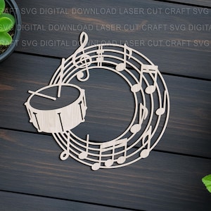May include: A wooden musical-themed cutout featuring a drum and musical notes arranged in a circular design. The design includes a treble clef and various musical notes. The background is a dark wooden surface with potted plants.