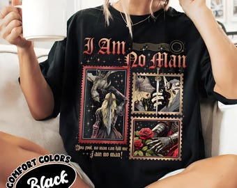May include: Black t-shirt with the text "I Am No Man" in a gothic font. The shirt features four postage stamp-style illustrations with fantasy themes. The words "Comfort Colors" and "Black" are also printed on the shirt.