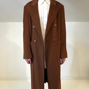 Könnte beinhalten: Ein Set aus drei Keramikbechern mit gesprenkelter, matter Oberfläche. Die Becher sind in Creme-, Hellgrau- und Dunkelgrautönen gehalten. Jeder Becher hat ein schlichtes, modernes Design und einen abgerundeten Henkel.