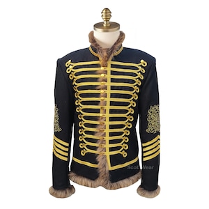 Könnte beinhalten: Schwarze Jacke im Militärstil mit goldfarbenen Zierleisten und Kunstfellkragen und -bündchen. Die Jacke hat mehrere Reihen goldfarbener Borten und dekorative goldfarbene Knöpfe. Die Ärmel haben goldfarbene Streifen und gestickte Details.