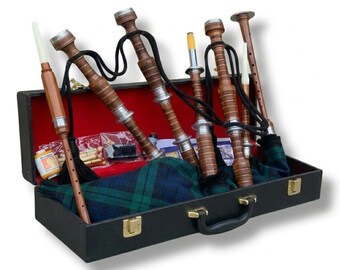 Può includere: Un set di cornamuse in una custodia nera con interno rosso. Le cornamuse sono realizzate in legno e metallo, con corde nere e una sacca a scozzese verde e blu. La custodia è aperta, rivelando gli strumenti e gli accessori.