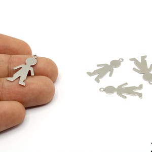 May include: Silver-coloured metal charms shaped like stick figures. One charm is held in a hand, with three others on a white surface. The charms are approximately 2.4cm in size.
