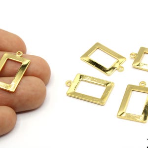 May include: Gold-colored rectangular pendant charms with a hollow center and a small loop at the top for attaching to jewelry. The charms are approximately 0.9 inches in length. Several charms are displayed on a white background.