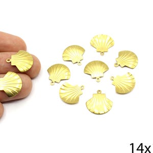 May include: A set of 10 gold-toned metal seashell charms, each measuring 14mm by 12mm. The charms have a loop at the top for attaching to jewellery or other crafts.