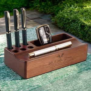 May include: A dark wooden desk tidy with a pen holder, a slot for a car key, and a tray for a pen. The organiser has the text "Mr & Mrs Small" and "Thanks for being part of our celebration! 20th January 2024".