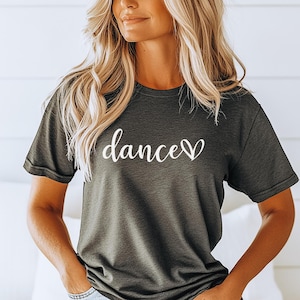 Könnte beinhalten: Dunkelgraues T-Shirt mit dem Wort "dance" in weißer Schrift, ein Herz ersetzt den Buchstaben "e". Das kurzärmelige Shirt ist aus einem weichen Material.