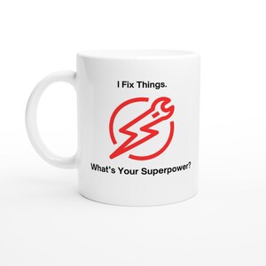 May include: White ceramic mug with a black and red design. The mug says "I Fix Things. What's Your Superpower?" with a red lightning bolt and wrench inside a red circle.