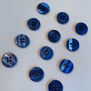 May include: Twelve blue plastic buttons with four holes each. The buttons have a light blue and dark blue swirl pattern.
