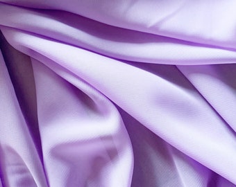 May include: A close-up of soft, light purple fabric with smooth, flowing folds.