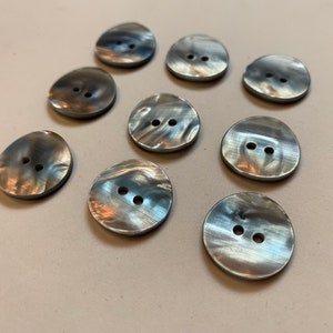 May include: Ten round, gray, two-hole buttons with a marbled effect.
