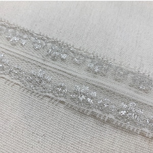 Domestic lace trim white and metallic silver 1 1/4” wide white scalloped trim light weight scalloped trim sold by the yard