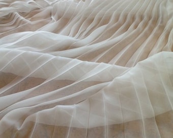 May include: White pleated fabric with a soft, flowing texture. The fabric is sheer and delicate, with a subtle sheen.