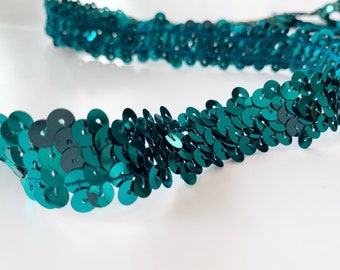 Pode incluir: Trimming de lantejoulas azul turquesa com acabamento brilhante. O trimming é feito de pequenas lantejoulas redondas costuradas juntas em uma linha contínua.