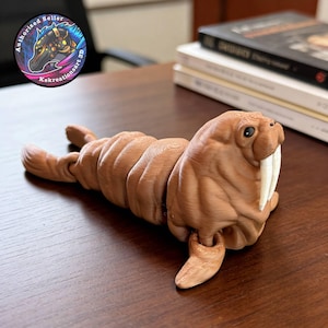 May include: A brown 3D-printed articulated walrus figurine with large tusks and a detailed textured surface. The walrus is lying down with its flippers extended. The figurine is on a wooden surface.