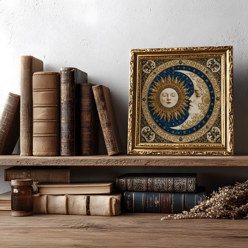 May include: A square framed artwork featuring a central circular illustration of a sun and moon with human faces, surrounded by a blue and gold celestial pattern. The frame is ornate, metallic gold, and rectangular with intricate embossed detailing.