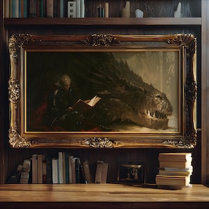 Peut inclure: Peinture encadrée dans un cadre doré orné, représentant une personne lisant à côté d'un dragon. L'œuvre est placée devant une bibliothèque en bois sombre. Une pile de livres est sur la surface en bois en dessous.