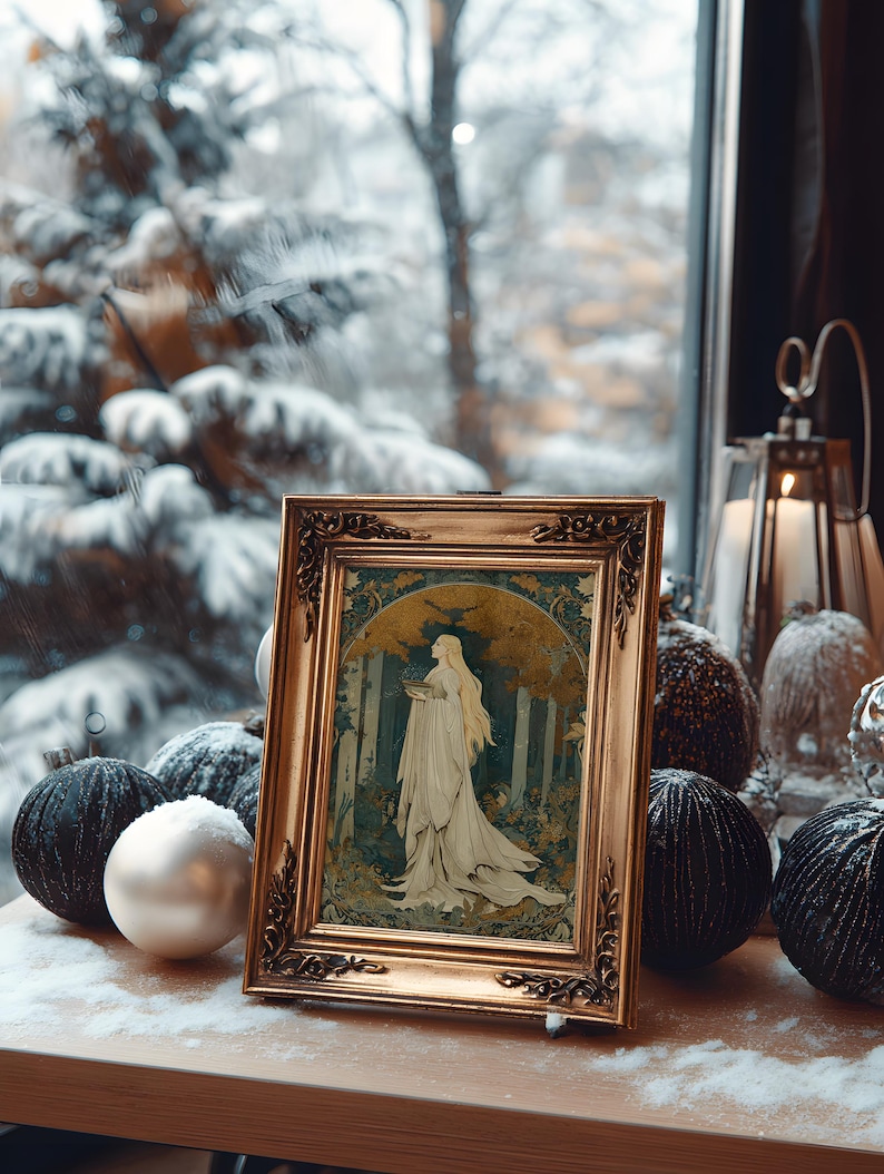 Op de afbeelding: Een ingelijst kunstwerk met een gouden, sierlijke lijst toont een vrouw in een witte jurk in een bosrijke omgeving. Het kunstwerk staat op een houten oppervlak met decoratieve zwarte en witte ornamenten, met een besneeuwde sc&egrave;ne zichtbaar door een raam.