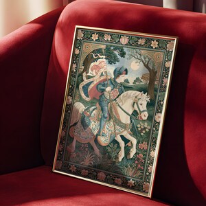 May include: Framed tapestry art featuring a knight on horseback in a medieval scene. The artwork has a gold frame and is set against a red velvet background. The tapestry depicts a knight in armor, a white horse, and a detailed floral border.