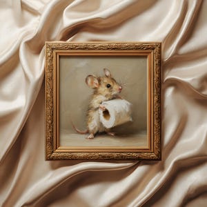 May include: A square oil painting in an ornate gold frame depicting a small brown mouse holding a white roll of toilet paper. The mouse has large ears, whiskers, and a long tail, standing on a neutral surface against a muted beige background.