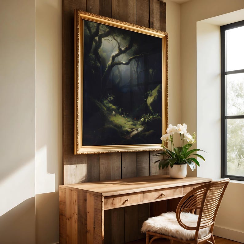 May include: A framed landscape painting with a gold ornate frame hangs above a wooden desk. The painting depicts a dark forest scene with a path leading into the distance. A white orchid plant sits on the desk near a window.