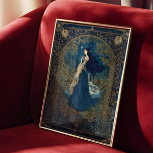 May include: A framed art print featuring a woman in a blue gown standing near a stream in a forest. The artwork has a gold frame and a dark blue and gold color scheme. The print is displayed on a red velvet couch.