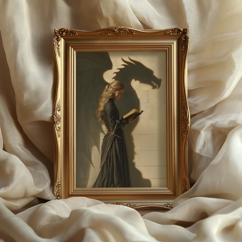 May include: A framed artwork featuring a woman in a dark dress reading a book, with a dragon shadow behind her. The gold frame has ornate detailing. The artwork evokes a fantasy theme.