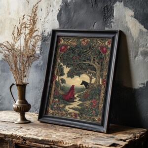 May include: Framed art print featuring a scene from a fairy tale. The artwork depicts a figure in a red cloak walking on a path towards a wolf under a tree. The frame is black, and the artwork has a vintage aesthetic with floral and tree details.
