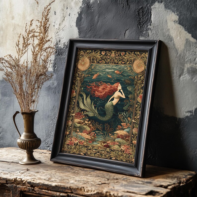 May include: Framed art print featuring a mermaid with flowing red hair and a green tail, set in an underwater scene with coral and fish. The artwork is in a dark wooden frame, leaning against a textured wall.