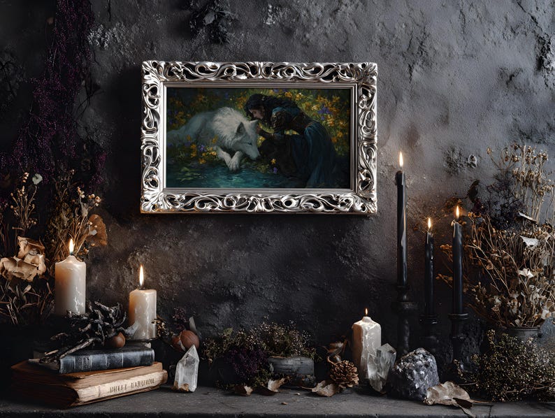 May include: A framed artwork with a silver ornate frame depicts a woman and a white wolf. The scene is set against a dark background, with lit candles, books, and crystals. The overall aesthetic is gothic and mystical.