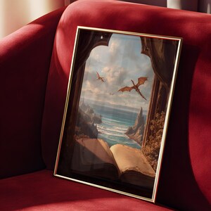 May include: A framed art print featuring a fantasy landscape with dragons soaring over a coastal scene. The artwork is set within a golden frame and depicts an open book in the foreground, with a red velvet sofa in the background.