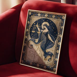 May include: A framed art print featuring a celestial illustration of a woman holding scales, representing Libra. The artwork is set against a dark blue starry background with gold accents, framed in a gold border. The print is displayed on a red velvet surface.