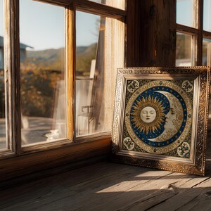 May include: A square framed artwork featuring a central circular design of a golden sun face and a cream-colored crescent moon face set against a deep blue background filled with gold stars, all enclosed in an ornate metallic gold frame.