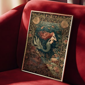 May include: Framed art print featuring a mermaid with flowing red hair and a green tail, swimming in an underwater scene. The artwork has a gold frame and is set against a dark blue background with coral and fish. The print is displayed on a red velvet couch.