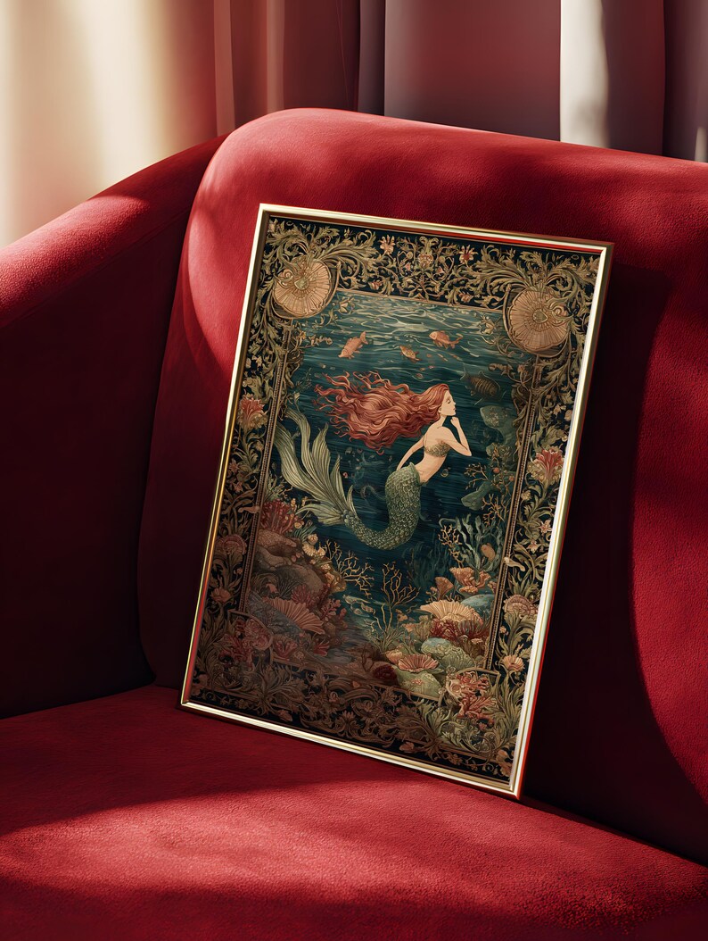 May include: Framed art print featuring a mermaid with flowing red hair and a green tail, swimming in an underwater scene. The artwork has a gold frame and is set against a dark blue background with coral and fish. The print is displayed on a red velvet couch.