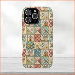 May include: A phone case with a patchwork design featuring houses, birds, and flowers in shades of red, blue, green, and yellow.