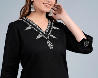 May include: A black linen kurta with silver embroidery featuring a floral design. The kurta has a V-neckline and three-quarter sleeves. The model is wearing silver jhumka earrings.