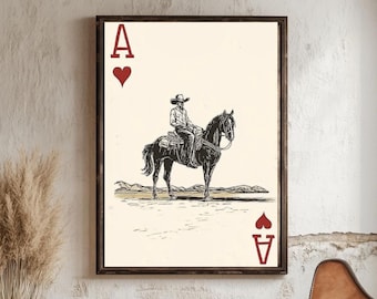 Op de afbeelding: Een ingelijste kunstprint met een cowboy te paard in een woestijnlandschap. Het ontwerp is de Aas van Harten van een speelkaart. Het kunstwerk is in zwart-wit met een vintage esthetiek, geschikt voor Western-thema decoratie.