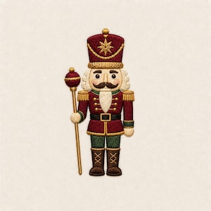 Puede incluir: Un parche bordado de un cascanueces con uniforme granate y detalles dorados, un sombrero alto con una estrella dorada y un bastón rematado en una esfera granate. La figura tiene barba blanca, bigote oscuro y botas marrones sobre tela clara.
