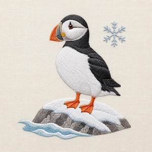 Könnte beinhalten: Ein gestickter Papageientaucher mit schwarzem Kopf, weißer Brust sowie orangefarbenem Schnabel und Füßen, der auf einem schneebedeckten Felsen über hellblauem Wasser steht. Ein kleines, hellblaues Schneeflockensymbol befindet sich rechts vom Vogel.