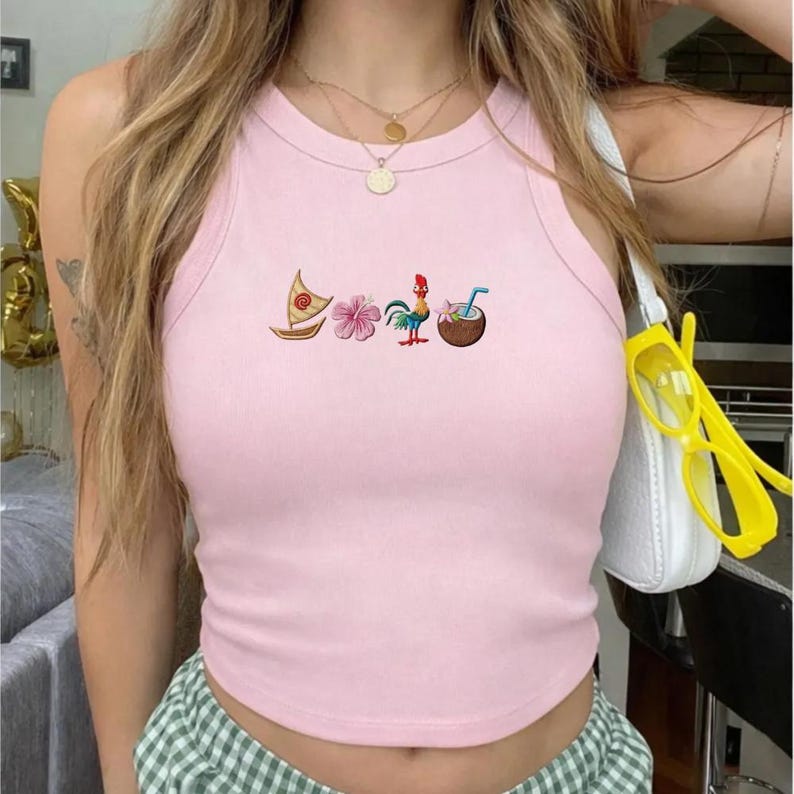 May include: Pink tank top with embroidered tropical designs, including a sailboat, flower, rooster, and coconut drink. The top has a round neckline and is sleeveless. The fabric appears to be a soft, lightweight material.