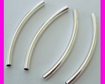 May include: Four curved, silver-colored metal tubes. Each tube has a hollow center and is slightly curved. The tubes are arranged on a light background, with a bright pink border.