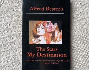 May include: A hardcover book titled "Alfred Bester's The Stars My Destination" with a black cover. The cover features an illustration of two people and text in red and white. A quote by Samuel R. Delany is also included.