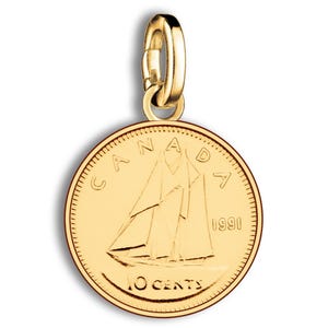 Pode incluir: Um berloque dourado com uma moeda canadense de 10 centavos de 1991. A moeda retrata um veleiro e a palavra "CANADA" no topo, com "10 CENTS" na parte inferior. O berloque tem um fecho dourado.