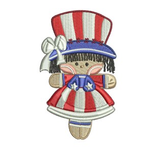 May include: Embroidered patch of a girl doll wearing a red, white, and blue dress and hat. The doll has black hair and a white face with red cheeks.