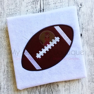 May include: A brown and white embroidered football design on a white fabric background.