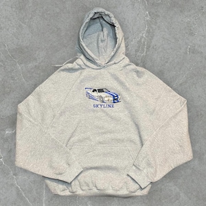 May include: A grey hooded sweatshirt with a white car graphic and the word "SKYLINE" printed in blue on the front.