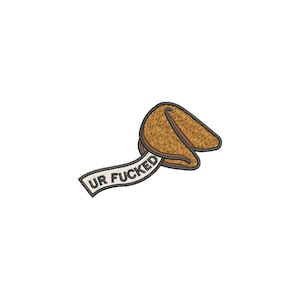Puede incluir: Galleta de la fortuna bordada con el texto "UR FUCKED" en una pancarta blanca. La galleta es marrón con un contorno marrón más oscuro. La pancarta es blanca con texto negro y un borde gris.